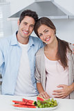 Pregnant woman and her husband standing together