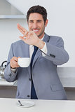 Happy businessman waving at someone in the kitchen