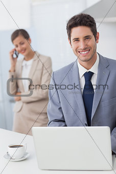 Happy businessman using a laptop before going to work