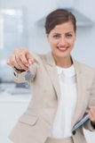 Pretty real estate agent offering house key
