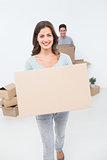 Attractive woman holding boxes in her new house