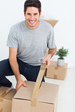 Cheerful man wrapping a box
