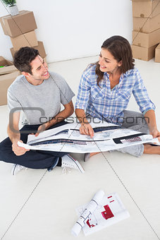 Happy woman and her husband looking at their house plans