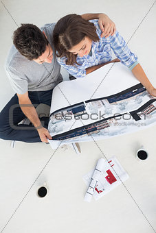 Overview of a man and his wife holding house plan