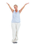Smiling woman standing with hands up in air