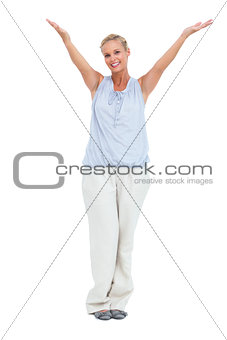 Smiling woman standing with hands up in air