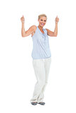 Blonde woman standing with thumbs up