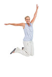 Blonde woman jumping with hands up in air