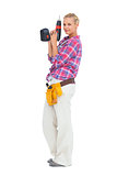 Smiling woman standing holding a drill