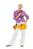 Happy woman standing holding a drill