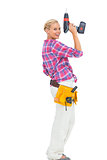 Blonde woman standing holding a drill