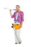 Blonde woman standing while holding a spirit level