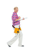 Blonde woman standing while playing with a spirit level