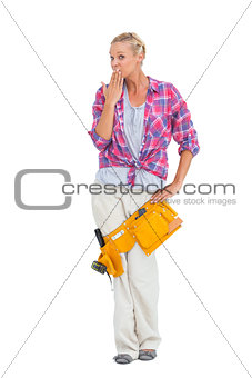 Surprised young woman wearing tool belt