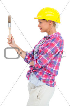 Happy handy woman looking at her paintbrush