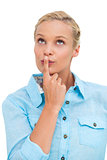 Blonde woman standing with her finger on her lips
