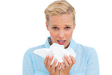 Blonde sick woman holding lots of tissues