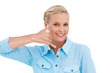 Smiling blonde looking at camera and doing a symbol of phone with her hand