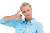 Blonde doing a symbol of phone with her hand and looking at camera