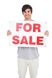 Man holding a for sale panel