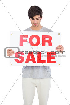 Man looking at a for sale board