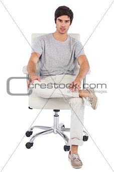 Serious man sitting on a swivel chair