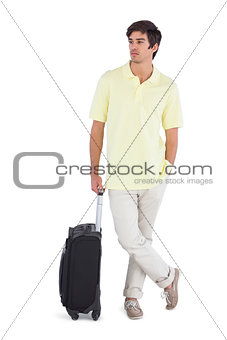 Thoughtful man standing with his suitcase