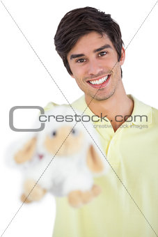 Young man holding sheep plush