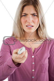 Irritated woman using remote control