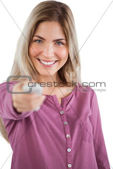 Smiling young woman changing channel