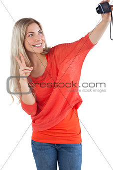 Woman making peace sign while taking a picture of herself
