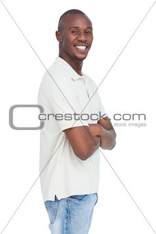 Smiling young man standing with arms crossed