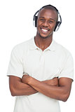 Smiling man listening to music with arms crossed