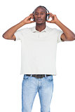 Man listening to music with hands on his headphones