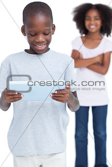 Little boy looking at a tablet pc with his sister