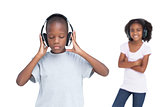 Little boy with eyes closed listening to music with his sister