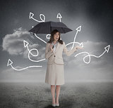 Businesswoman with jumbled arrows holding umbrella