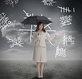Businesswoman with noughts and crosses holding umbrella