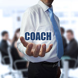 Elegant businessman holding the word coach