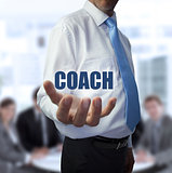 Smart businessman holding the word coach