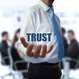 Smart businessman holding the word trust