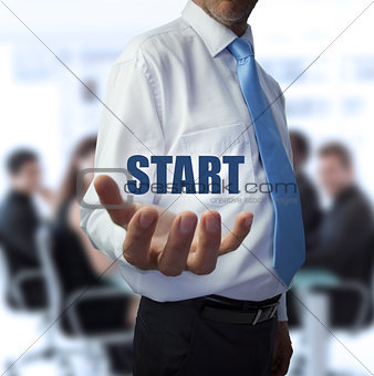 Businessman holding the word start