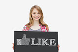 Smiling girl holding panel with thumb up representing social network logo