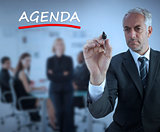 Sophisticated businessman underlining in red the word agenda