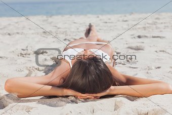 Woman lying on beach in front of ocean