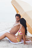 Couple speaking together on beach towel