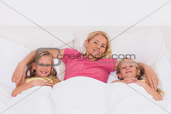 Woman lying in bed with her children