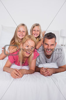 Parents lying in bed with their twins