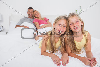 Twins posing in bed in front of their parents