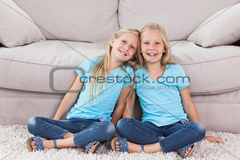 Twins sitting on a carpet